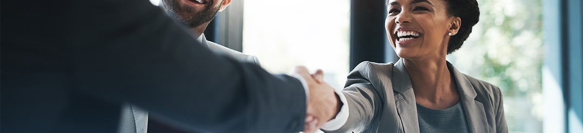 A businessman shakes hands with a businesswoman